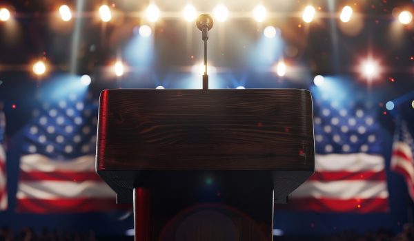 podium stage with american flags bright lights suggesting political patriotic event